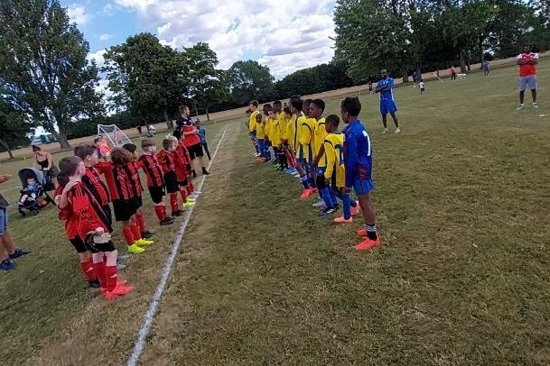 Two teams lined up before a youth match