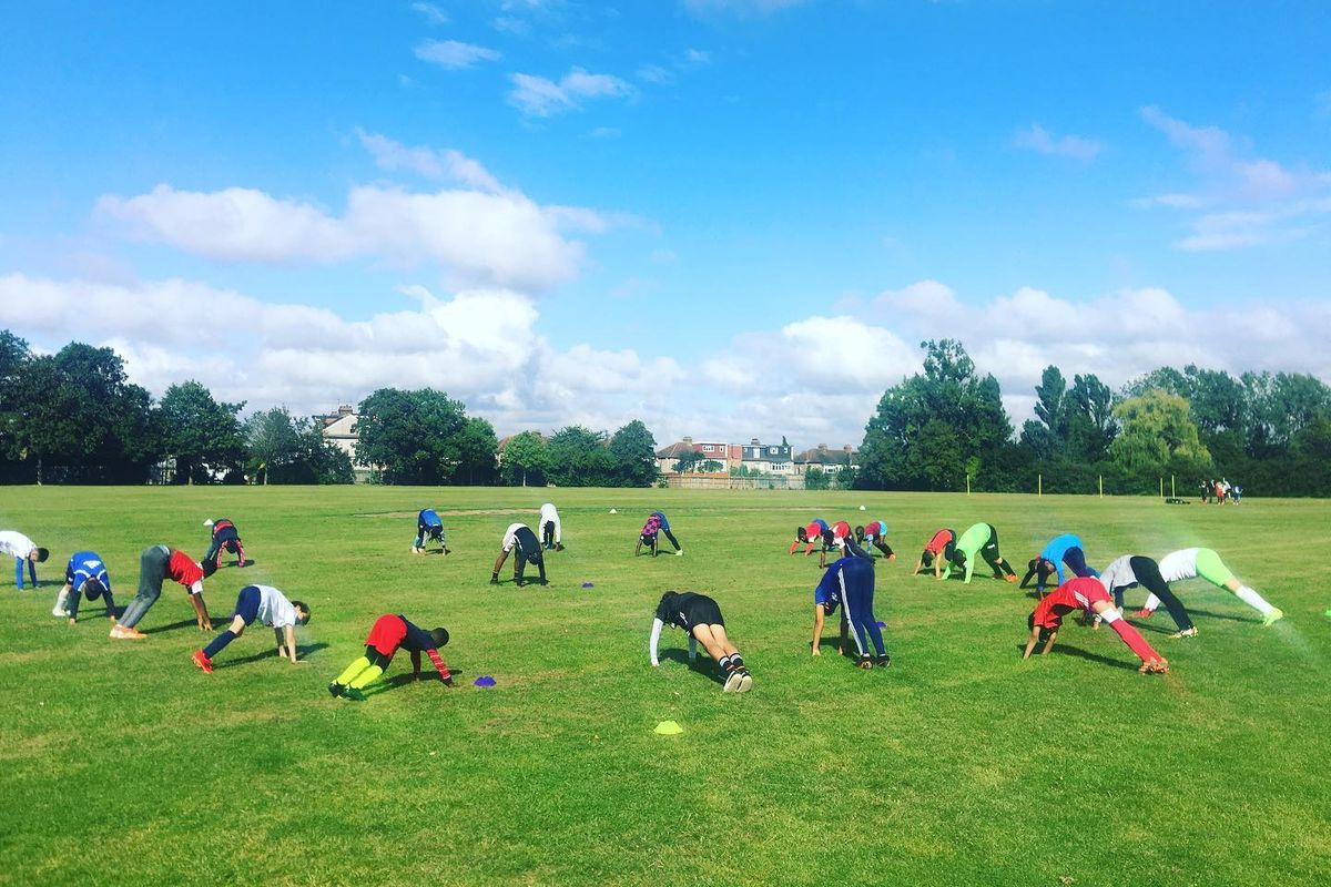Players stretching during a warm-up on a sunny Saturday